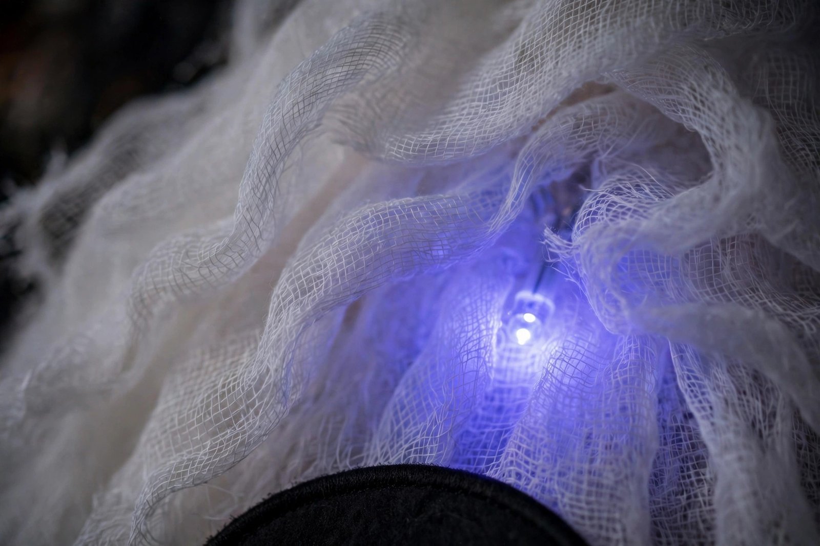 Close-up of the JOYIN light-up hanging ghost: white gauze fabric with a glowing blue LED light shining through