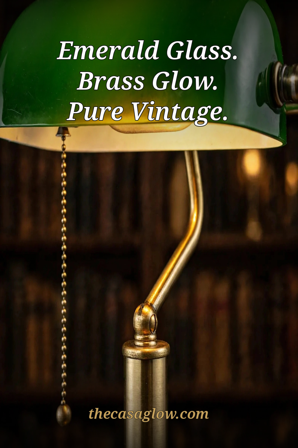 Close-up of the TORCHSTAR banker's lamp emerald glass shade, brass arm and beaded pull chain glowing warm