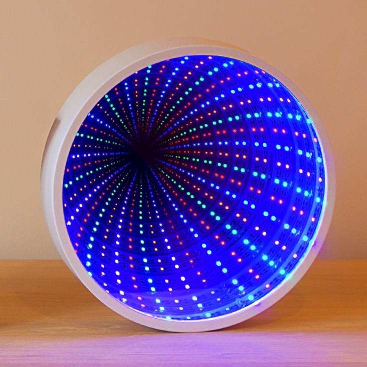 The Glowhouse infinity mirror tunnel lamp glowing on a shelf